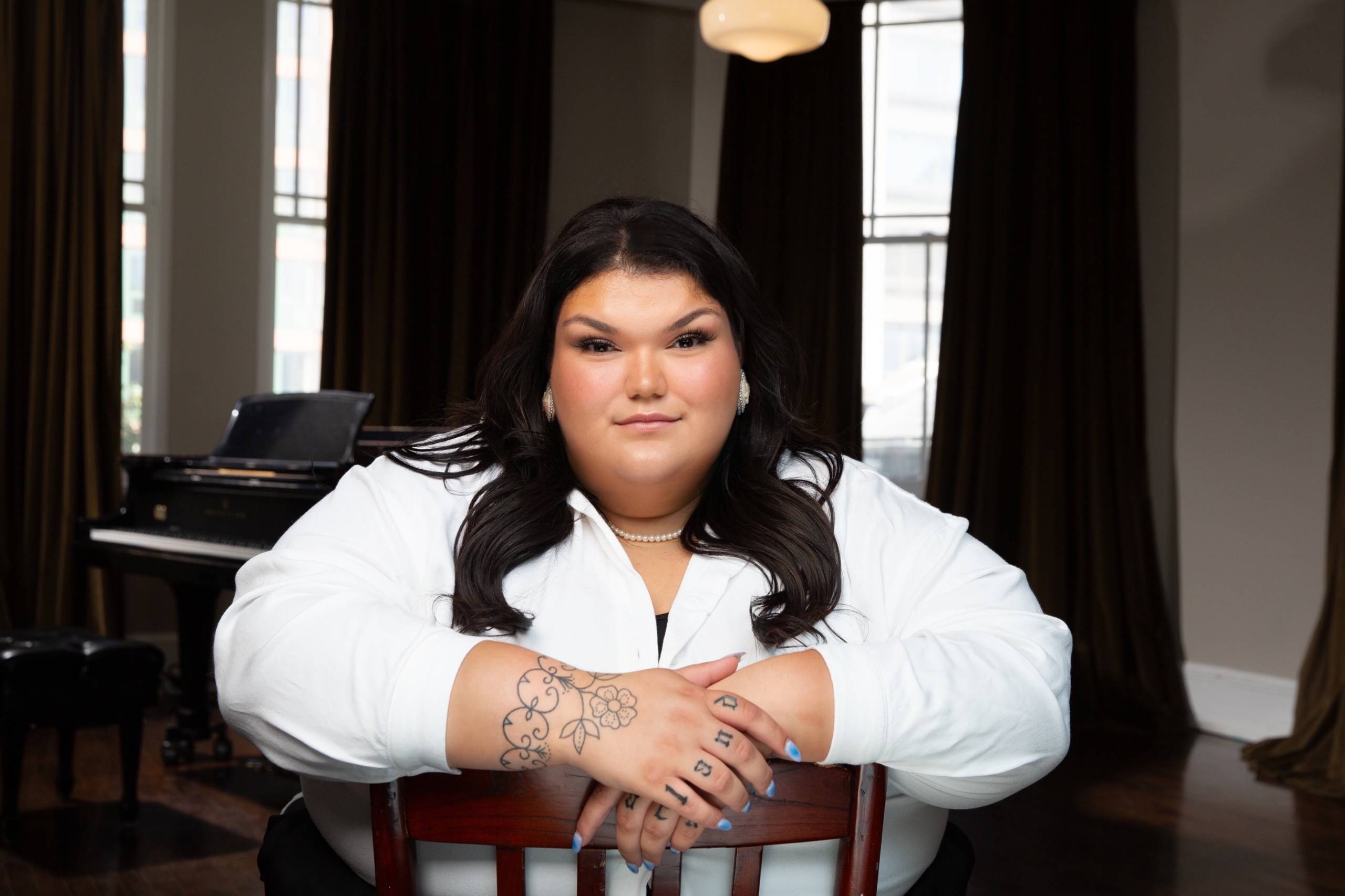 Emma Pennell sitting on a chair with arms crossed.