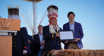Chief Ouray Crowfoot and Prime Minister Trudeau at an event recognizing the land settlement claim