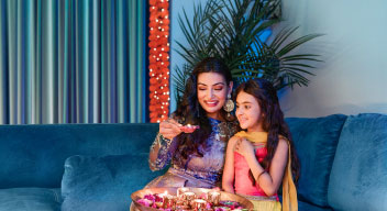 A mother and daughter in cultural dress celebrating Diwali.