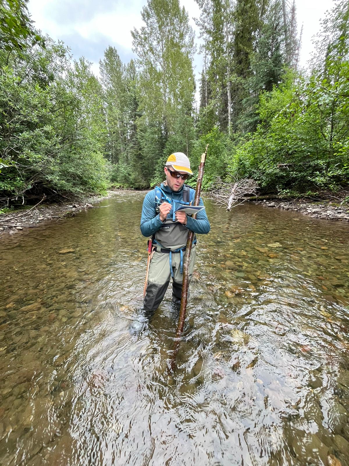 Chris Cail stands in a river