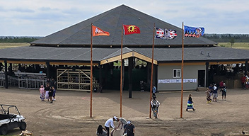 Outdoor community gathering space with open-air pavilion featuring a dark peaked roof.